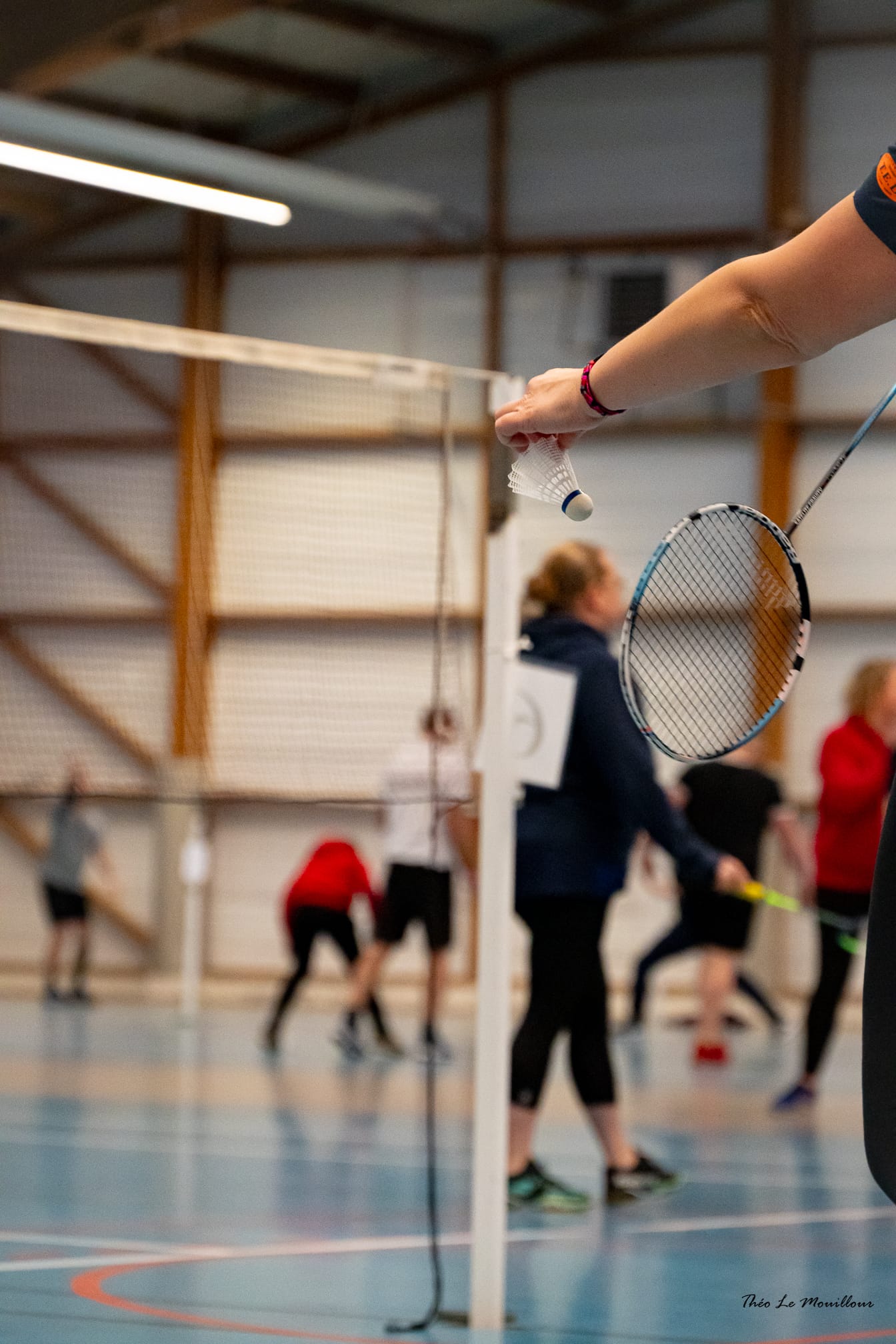 Service avec un volant et une raquette de badminton